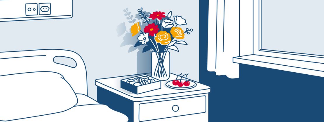 Illustration von einem Nachttisch neben dem Spitalbett. Auf dem Tischchen befinden sich Blumen, Pralinen und Kirschen.